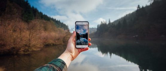 GlobalReach-man using phone by lake
